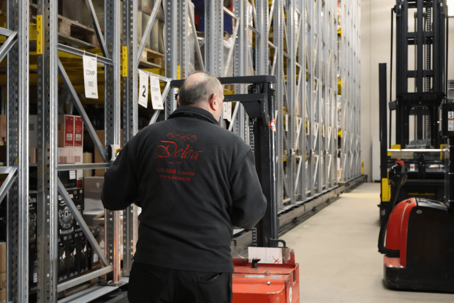 Magazzino con le scaffalature e un collaboratore Delea al transpallet